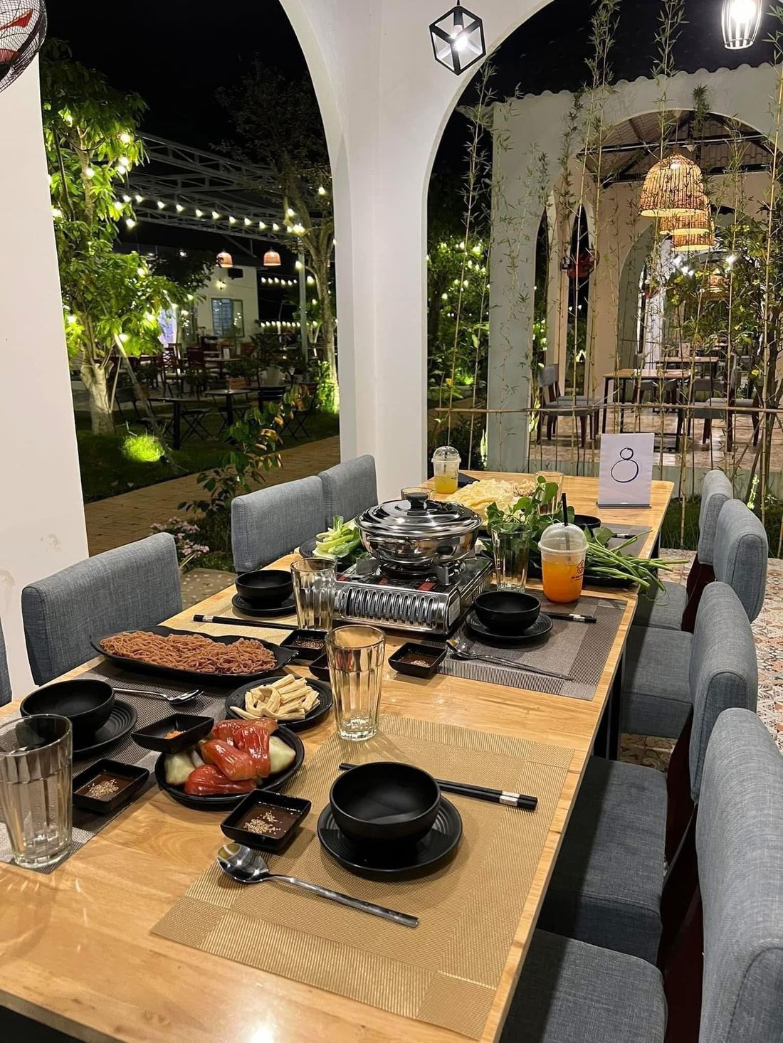 Bàn lẩu setup ngoài trời ban đêm tại Thế Giới Lẩu Chay - Sắc Màu Trảng Bàng - khu vòm + bụi tre + đèn nan